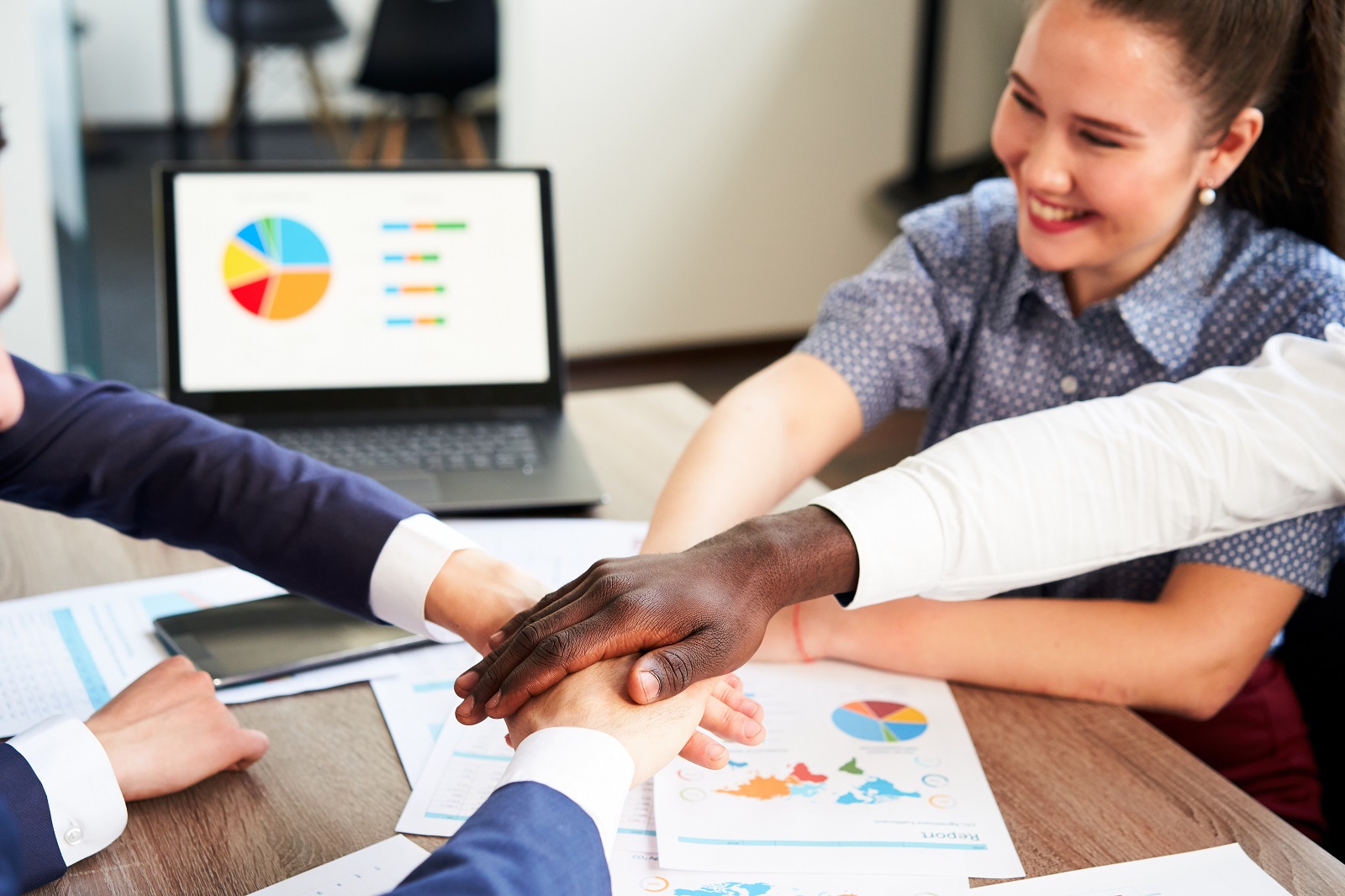 1600international business team showing unity with their hands stacked together pile